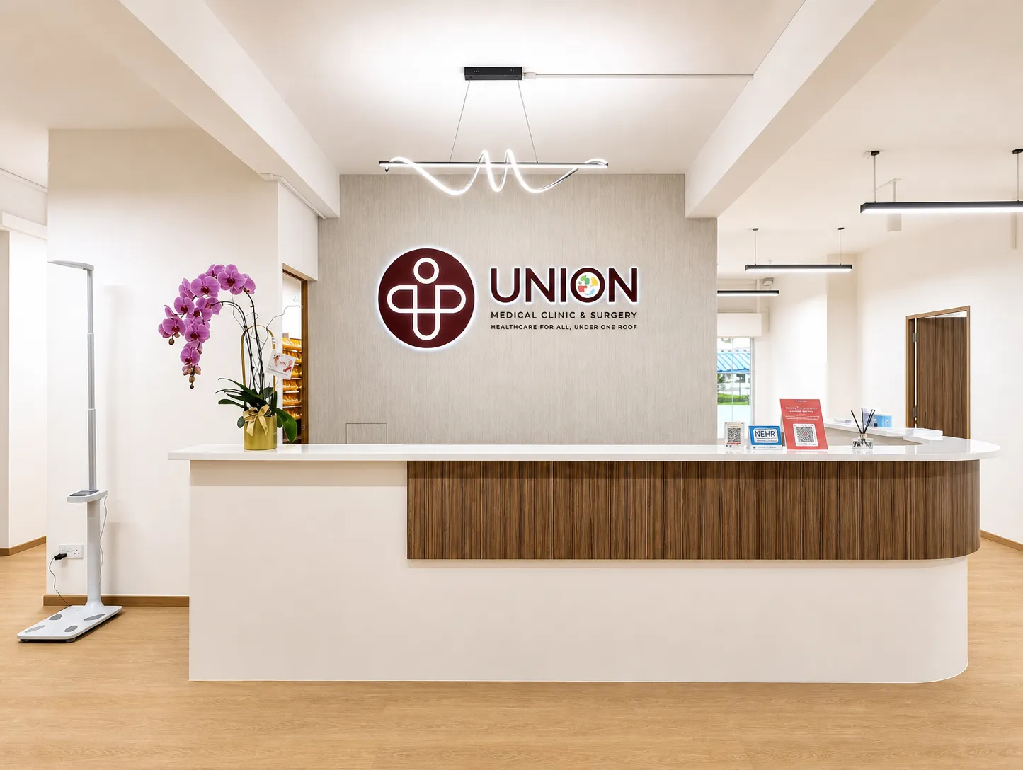 Reception counter at Union Medical Clinic & Surgery in Toa Payoh, with the clinic logo on the wall